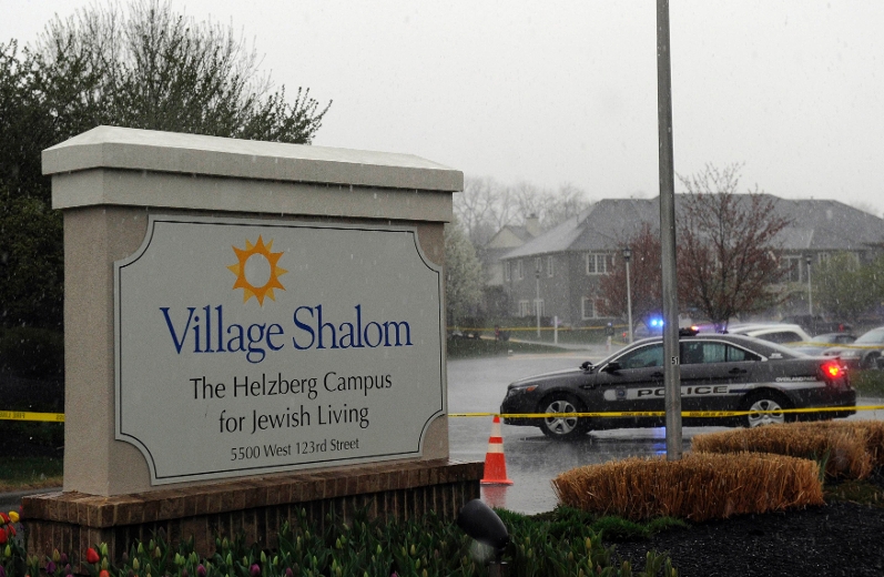 A police car blocks the scene of a shooting at Village Shalom, an assisted living center, as rain falls in Overland Park, Kansas